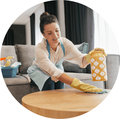 Person cleaning a wooden table.
